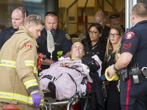 A police officer is wheeled on a stretcher out of the Sears in Marlborough Mall in Calgary, Alta., on Saturday, Sept. 17, 2016. Details on the incident were not immediately made known. Lyle Aspinall/Postmedia Network