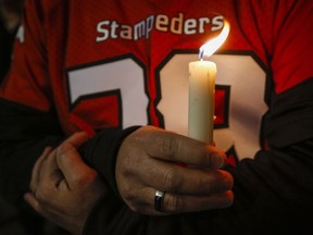 Mourners gather at a candle light vigil for Stampeders player Mylan Hicks in Calgary, Alta., Wednesday, Sept. 28, 2016.