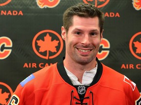 Newly acquired Troy Brouwer tries on the Flames jersey as the Calgary Flames announced the signing in Calgary, Alta on Friday July 1, 2016.