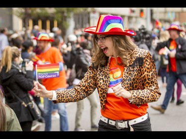 MLA Jessica Littlewood hands out flags during the Calgary Pride Parade in the city's downtown core on Sunday, Sept. 4, 2016. About 60,000 people were expected to watch the annual parade, as more than 125 entries took part. Lyle Aspinall/Postmedia Network