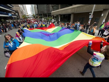 A giant pride flag is walked through the Calgary Pride Parade in the city's downtown core on Sunday, Sept. 4, 2016. About 60,000 people were expected to watch the annual parade, as more than 125 entries took part. Lyle Aspinall/Postmedia Network