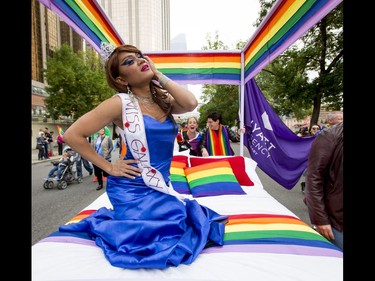 Karla Montecarlo rides with a Hyatt Regency float in the Calgary Pride Parade in the city's downtown core on Sunday, Sept. 4, 2016. About 60,000 people were expected to watch the annual parade, as more than 125 entries took part. Lyle Aspinall/Postmedia Network