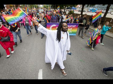 Stephane Youdom walks with Hillhurst United Church in the Calgary Pride Parade in the city's downtown core on Sunday, Sept. 4, 2016. About 60,000 people were expected to watch the annual parade, as more than 125 entries took part. Lyle Aspinall/Postmedia Network