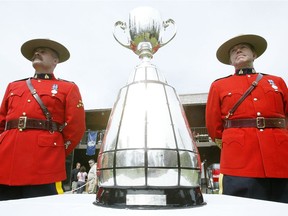 RCMP officers Stu Beasley (l) and Steve Saunders keep a close eye on the Grey Cup after it made an appearence at the Grey Cup Golf Tournament at Elhurst Golf  Country Club Wednesday, May 31, 2006.n/a