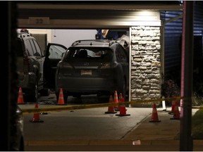 Evidence marked by pylons in the driveway after a shooting on Redstone Manor NE .