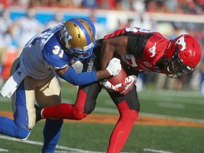 Stampeders receiver Kamar Jorden (R) makes a reception and is tackled by Blue Bombers Maurice Legget (L) during CFL action between the Calgary Stampeders and the Winnipeg Blue Bombers in Calgary on September 24, 2016.