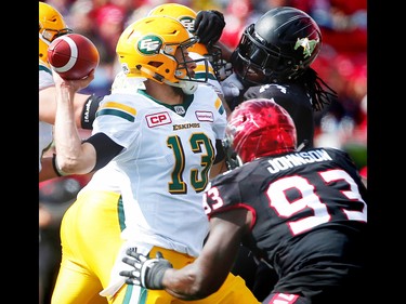 Edmonton Eskimos quarterback Mike Reilly throws under pressure from Junior Turner and Micah Johnson of the Calgary Stampeders during CFL football in Calgary, Alta., on Monday, September 5, 2016.