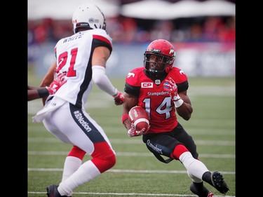 Calgary Stampeders Roy Finch runs the ball against Mitchell White of the Ottawa Redblacks during CFL football in Calgary, Alta., on Saturday, September 17, 2016.