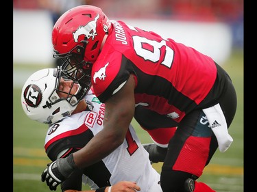 Calgary Stampeders Micah Johnson brings down quarterback Trevor Harris of the Ottawa Redblacks, Micah Johnson was penalized on the play , for roughing the passer, during CFL football in Calgary, Alta., on Saturday, September 17, 2016.