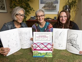 (L-R) Sandra Hayes-Gardiner, Carolyn Pogue and Lindsay Fenton of Hillhurst United Church pose for a photo with 'Colouring Peace in Calgary' at Pogue's home in Calgary, Alta., on Thursday, Sept. 29, 2016. Their art group at the church made a Calgary-themed colouring book for refugees and other newcomers, with writing in English, Arabic and Blackfoot. Lyle Aspinall/Postmedia Network