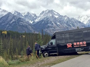 Police check a bus that went over an embankment near Banff Wednesday.