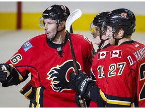 Calgary Flames' Troy Brouwer, left, celebrates his goal with Matthew Tkachuk, center, and Dougie Hamilton, during first-period preseason NHL hockey game action against the Vancouver Canucks in Calgary, Alberta, Friday, Sept. 30, 2016.