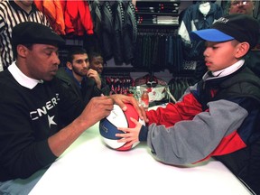 FILE PHOTO — Vincent Garcia, 10, of Mississauga gets his ball autographed yesterday by former NBA great Julius (Dr. J) Erving. Dr. J was at the Eaton Centre as part of a shoe-promotion tour.