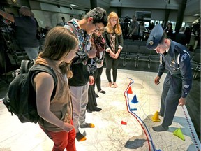 Army cadet Michael Batas and other young people walk on a floor map of Vimy Ridge during the launch of Spirit of Vimy in Calgary on Thursday.