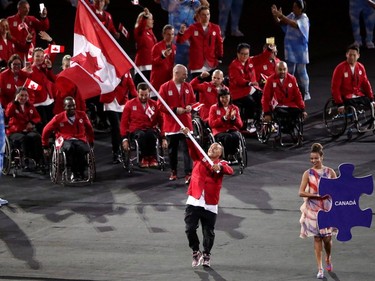 Wheelchair basketball player David Eng, carries the Canadain flag into the opening ceremonies of the Rio Paralympics in Rio De Janerio, Brazil  on Tuesday September 6, 2016. Leah hennel/Postmedia