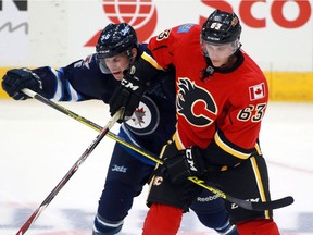 Winnipeg Jets' Jansen Harkins gets held up by Calgary Flames' Ryan Culkin during first period NHL rookie action in Penticton, B.C. on Friday September 11, 2015.
