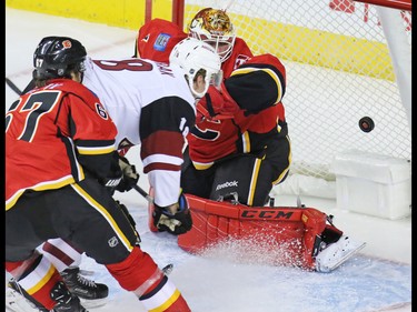 The Arizona Coyotes' Christian Dvorak watches the puck go past Calgary Flames goaltender Brian Elliott to score the first goal of the game during the first period NHL  preseason action at the Scotiabank Saddledome in Calgary, Wednesday Oct. 5, 2016.