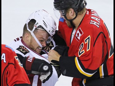 The Arizona Coyotes' Max Domi and the Calgary Flames Dougie Hamilton fight during the first period of their NHL preseason game at the Scotiabank Saddledome in Calgary, Wednesday Oct. 5, 2016.
