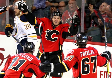 Calgary Flames Micheal Frolik, right, celebrates his first period goal on Buffalo Sabres with teammates Mikael Backlund, left and Lance Bouma, middle, in NHL hockey action at the Scotiabank Saddledome in Calgary, Alta. on Tuesday October 18, 2016. Leah Hennel/Postmedia