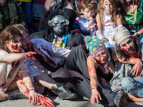 Dozens of the walking dead gather at Olympic Plaza to walk Stephen Ave and scare the living out of the living in Calgary, on October 17, 2015.