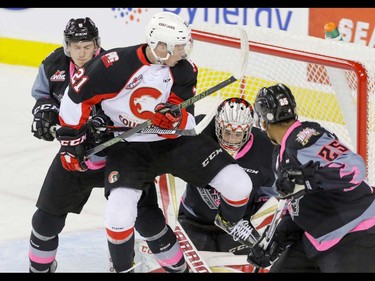 Calgary Hitmen goalie Cody Porter is screened by Prince George Cougars Jared Bethune as Hitmen Jayden Gordon and Aaron Hyman move in to help in WHL action at the Scotiabank Saddledome in Calgary, Alberta, on Saturday, October 29. Mike Drew/Postmedia