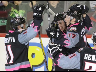 Calgary Hitmen Jordy Stallard is congratulated by teammates Beck Malenstyn, Taylor Sanheim and Matteo Gennaro after his goal won the game for the Hitmen in WHL action at the Scotiabank Saddledome in Calgary, Alberta, on Saturday, October 29. The Hitmen beat the Cougars in overtime 3-2. Mike Drew/Postmedia