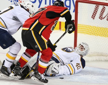 Calgary Flames Micheal Frolik, left, scores on Buffalo Sabres netminder Robin Lehner in NHL hockey action at the Scotiabank Saddledome in Calgary, Alta. on Tuesday October 18, 2016. Leah Hennel/Postmedia