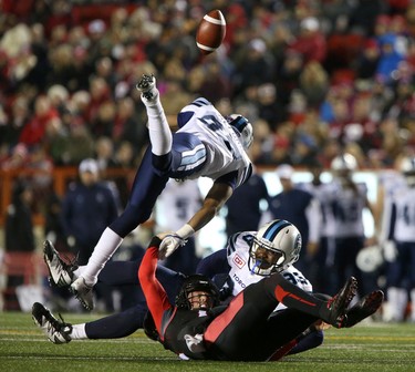 Toronto Argonauts, top, strips the ball from Calgary Stampeders Andrew Buckley as he collides with Argos Eric Martin during CFL action at McMahon Stadium in Calgary, Alta.. on Friday October 21, 2016.