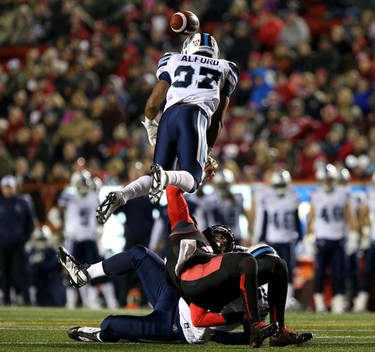 Toronto Argonauts, top, strips the ball from Calgary Stampeders Andrew Buckley as he collides with Argos Eric Martin during CFL action at McMahon Stadium in Calgary, Alta.. on Friday October 21, 2016.