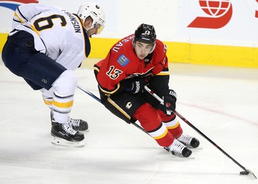Calgary Flames Johnny Gaudreau, right, skates the puck up the ice by Buffalo Sabres Cody Franson in NHL hockey action at the Scotiabank Saddledome in Calgary, Alta. on Tuesday October 18, 2016. Leah Hennel/Postmedia