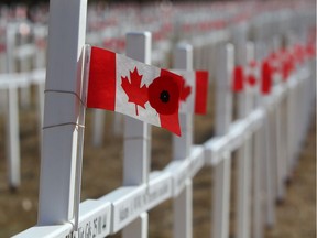 A poppy adorns a Canadian flag upon a sea of crosses set up on Memorial Drive in 2011.