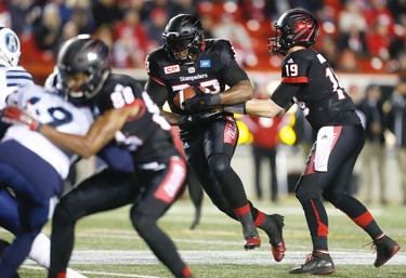 Calgary Stampeders quarterback, Bo Levi Mitchell, hands the ball off to running back Jerome Messam, during a game against the Toronto Argonauts in Calgary, Alta., on Friday, October 21, 2016.