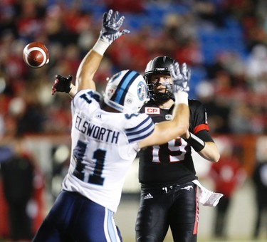 Calgary Stampeders Bo Levi Mitchell scrambles under pressure from Devon Wylie of the Toronto Argonauts during CFL football in Calgary, Alta., on Friday, October 21, 2016.