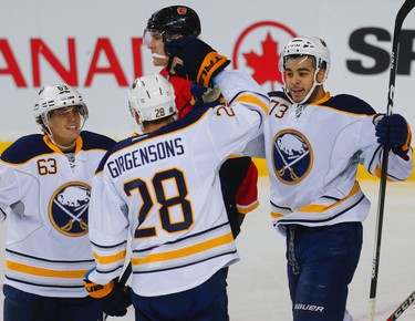 Buffalo Sabres # 28 Zemgus Girgensons celebrates with teammates Tyler Ennis and Nicholas Baptiste after scoring against Matthew Tkachuk and the Calgary Flames, during NHL hockey in Calgary, Alta., on Tuesday, October 18, 2016. AL CHAREST/POSTMEDIA