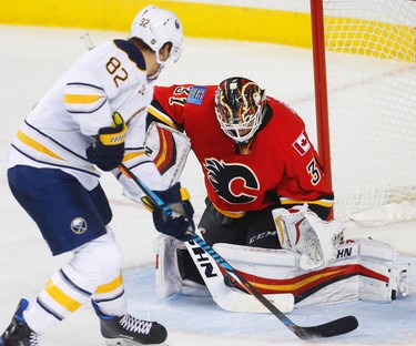 Flames Chad Johnson makes a save on a shot by Marcus Foligno of the Buffalo Sabres during NHL hockey in Calgary, Alta., on Tuesday, October 18, 2016.