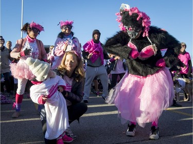 Brooklynn Wessner, 2, with her grandma Ruth Davies, a cancer survivor, eyes a dancing gorilla during the Canadian Breast Cancer Foundation CIBC Run for the Cure at Southcentre Mall in Calgary, Alta., on Sunday, Oct. 2, 2016.