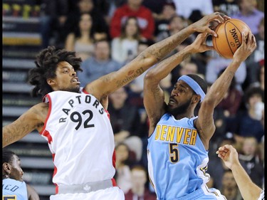 The Toronto Raptors' Lucas Nogueira blocks the Denver Nuggets' Will Barton during their NBA preseason game between at the Scotiabank Saddledome in Calgary on Monday Oct. 3, 2016.