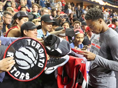 The Toronto Raptors' DeMar DeRozan signs autographs for fans before the NBA preseason game against the Denver Nuggets at the Scotiabank Saddledome in Calgary on Monday Oct. 3, 2016.