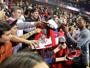 The Toronto Raptors' DeMar DeRozan signs autographs for fans before the NBA preseason game against the Denver Nuggets at the Scotiabank Saddledome in Calgary on Monday Oct. 3, 2016.