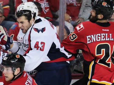 The Washington Capitals' Tom Wilson is checked by the Calgary Flames' Deryk Engelland during NHL action at the Scotiabank Saddledome in Calgary on Sunday October 30, 2016.