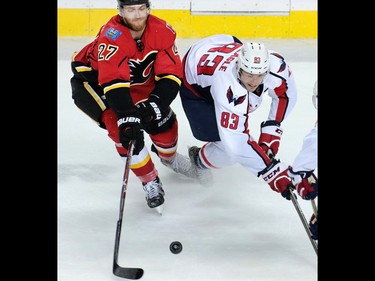 Calgary Flames defenseman Dougie Hamilton and the Washington Capitals' Jay Beagle fight for control of the puck during NHL action at the Scotiabank Saddledome in Calgary on Sunday October 30, 2016.