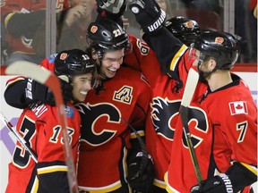 Calgary Flames Sean Monahan is congratulated by teammates Johnny Gaudreau, Deryk Engelland and TJ Brodie after scoring against the Ottawa Senators in NHL hockey action at the Scotiabank Saddledome in Calgary, Alta. on Friday October 28, 2016. The Flames beat the Senators 5-2.