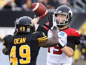 Calgary Stampeders quarterback Bo Levi Mitchell (19) passes as Hamilton Tiger Cats' Larry Dean defends during the first-half of CFL football action in Hamilton on Saturday, October 1, 2016.