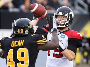 Calgary Stampeders quarterback Bo Levi Mitchell (19) passes as Hamilton Tiger Cats' Larry Dean defends during the first-half of CFL football action in Hamilton on Saturday, October 1, 2016.