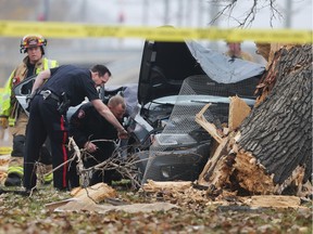 Police and fire personel investigate at the scene of a dramatic single car crash on Memorial Drive eastbound near Bridgeland Tuesday morning October 25, 2016. The driver had to be cut from the car after knocking down and large tree and is reportedly in  life threatening condition.