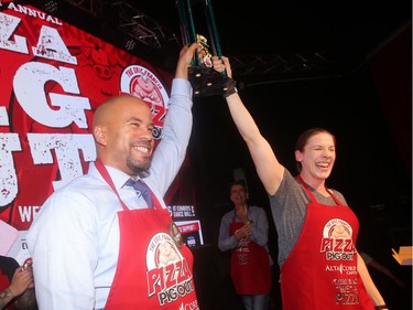 Co-Pigout Champions, former Stampeders running back Jon Cornish and retired Team Canada Rugby player Maria Samson raise their trophy at the annual Eric Francis Pizza Pigout Wednesday night October 19, 2016 at Cowboys.