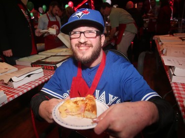 Dan Pederson tries out one of the pizza offerings at the annual Eric Francis Pizza Pigout Wednesday night October 19, 2016 at Cowboys.