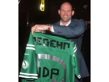 Former Flames defenseman Robyn Regehr holds up his Roughriders NDP jersey at the annual Eric Francis Pizza Pigout Wednesday night October 19, 2016 at Cowboys.