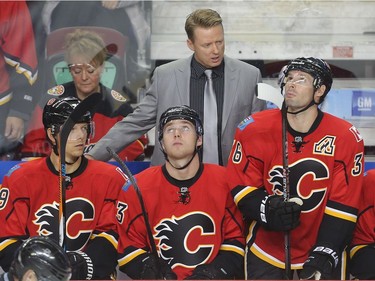 Calgary Flames coach Glen Gulutzan talks to players on the bench, from left Alex Chiasson, Sam Bennett and Troy Brouwer, late in the third period  of their 4-2 loss to Carolina Hurricanes at the Saddledome Thursday night October 19, 2016.