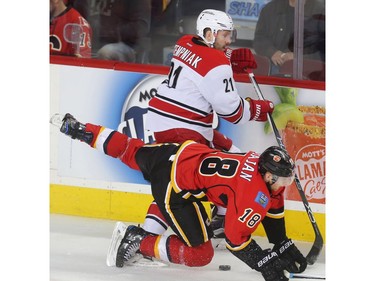 Matt Stajan of the Calgary Flames is knocked to the ice by former Flame Lee Stempniak of the Carolina Hurricanes in the second period at the Saddledome Thursday night October 19, 2016.